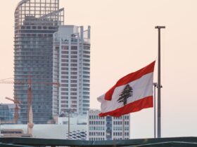 The Lebanese Flag on Pole with the Marina Tower in Beirut, Lebanon on Background