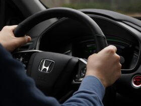 a person driving a car with a steering wheel