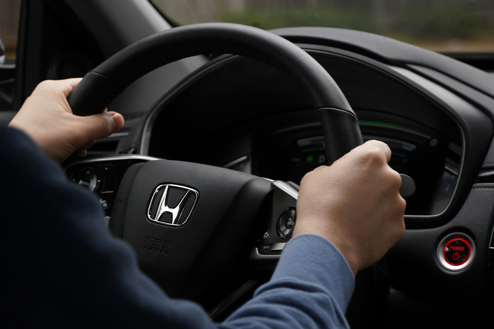 a person driving a car with a steering wheel